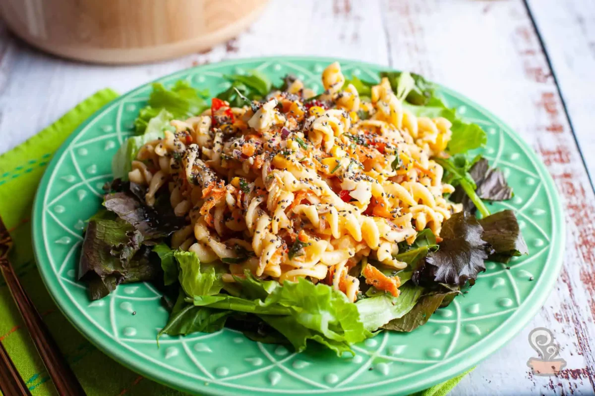Salada de macarrão com atum servida em prato verde